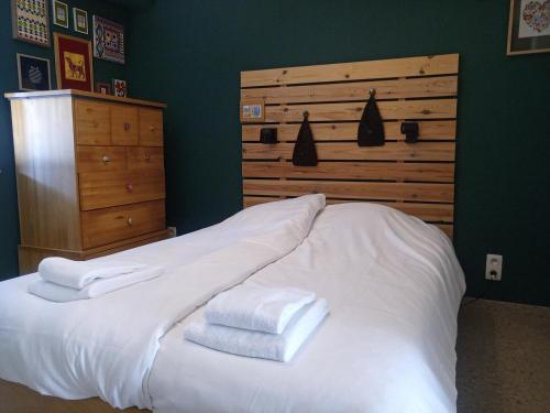 a bedroom with a white bed with towels on it at Klauwaards appartement in Kortrijk