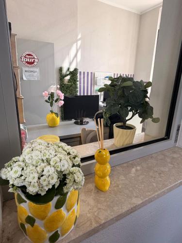 a counter with two vases of flowers and a mirror at Open Tours in Ełk