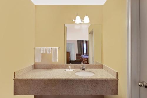 a bathroom with a sink and a mirror at Super 8 by Wyndham Siloam Springs in Siloam Springs