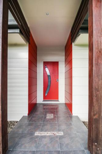 a red door in a red and white wall at WhitsunStays - Casa Crimson in Mackay