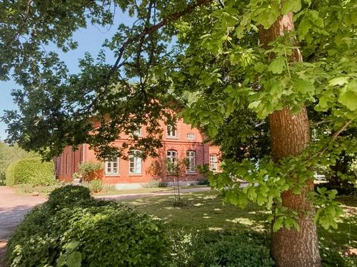 a red brick house with a tree in front of it at Apartment In A Converted 1875 Creamery in Travenhorst