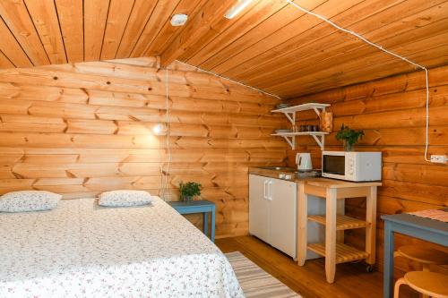 a bedroom with a bed in a wooden room at Taipaleen luomutila in Petäjävesi
