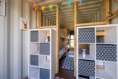 a room with white shelves and a door in a room at Container 11, Camp Tapnell in Yarmouth
