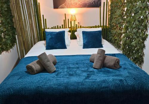 a bed with four brown pillows on it at L'Evasion Zen au cœur de l'Alsace in Sélestat