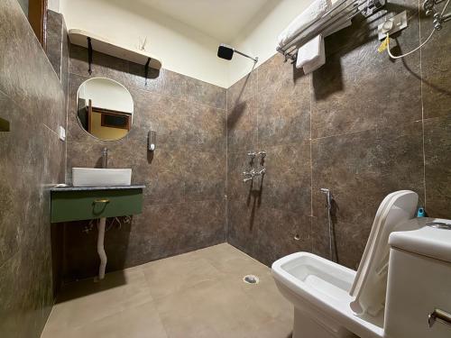 a bathroom with a sink and a toilet and a mirror at Tora House in Nagar
