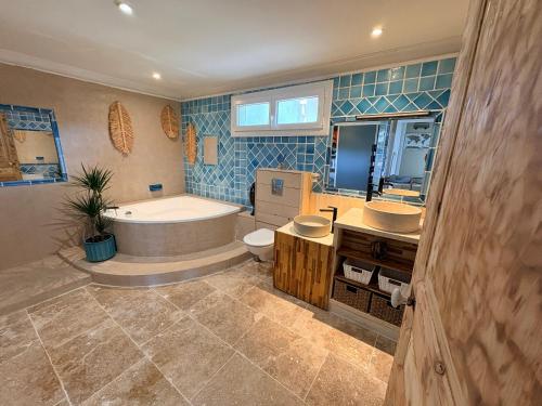 a bathroom with a tub and a toilet and a sink at Batisse de vacance cadre exceptionnel in Fréjus