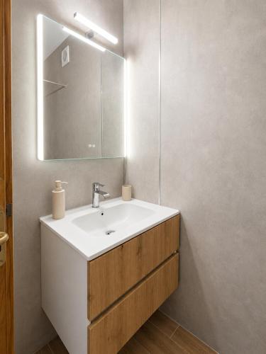 a bathroom with a white sink and a mirror at Ladario Studios in Sarti