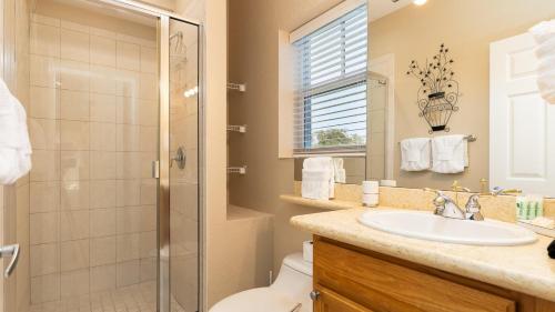 a bathroom with a shower toilet and a sink at 611 Mariners Club in Key Largo