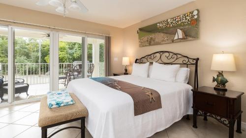 a bedroom with a large bed and a balcony at 611 Mariners Club in Key Largo