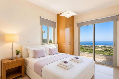 a bedroom with a bed with a view of the ocean at Villa Panorama Tessera in Drousha
