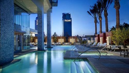 a swimming pool in a building with palm trees at Palms Place amazing Strip View 20th floor in Las Vegas