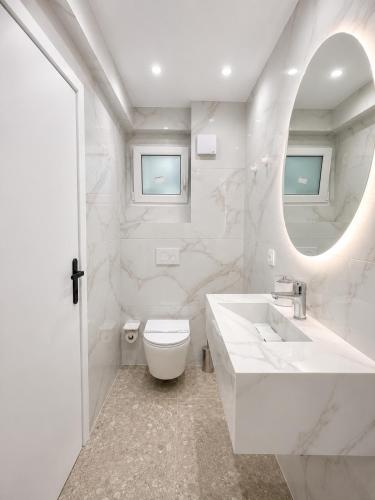 a bathroom with a sink and a toilet and a mirror at Xsoma Flats "Studio" in Thessaloniki