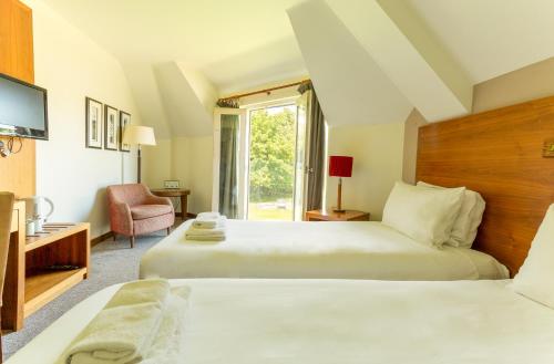 a hotel room with two beds and a window at Thorpeness Golf Club and Hotel in Thorpeness