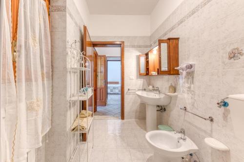 ein weißes Badezimmer mit zwei Waschbecken und einer Toilette in der Unterkunft Da lu Pira in Patù