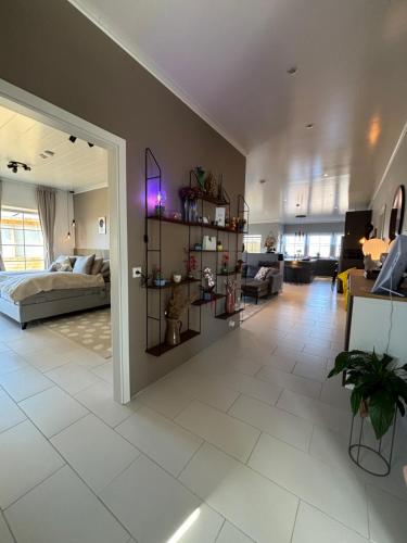 a living room with a bed and a white tile floor at BergÁs in Njarðvík
