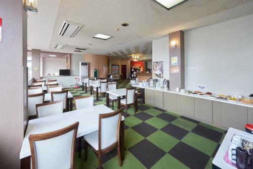 a dining room with tables and chairs and a counter at Select Inn Yonezawa in Yonezawa
