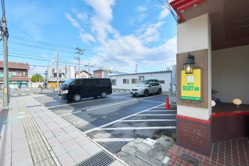 a street with cars parked in a parking lot at Select Inn Yonezawa in Yonezawa