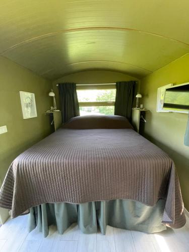 a bed in a small room with a window at Glamping Casetta sul lago 2 in Albairate