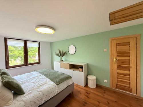 a bedroom with a bed and a table and a mirror at Dom Skośna Kraśnik in Kraśnik