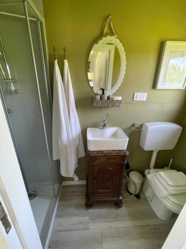a bathroom with a sink and a shower and a toilet at Glamping Casetta sul lago 2 in Albairate