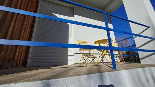 two chairs and a table on a balcony at Les Tournesols in Égletons