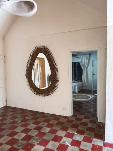 a mirror on a wall in a room with a checkered floor at Casa Martine in El Cuyo