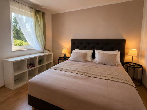 a bedroom with a large bed and a window at Apartment MAGAŠ in Vrbnik