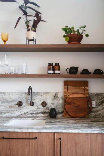 a kitchen counter with a sink and some plants at Edge Luxury Villas in Wilyabrup