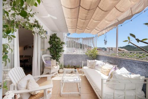 a living room with a couch and chairs on a balcony at Casa D’Amelia in Ojén