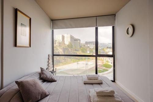 a bedroom with a large bed with a large window at Kóor Stays - Australis in Ushuaia