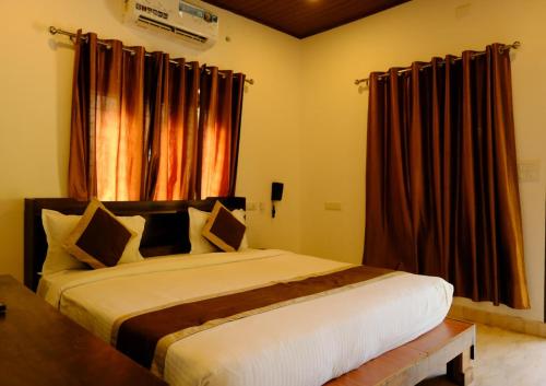 a bedroom with a large bed with brown curtains at Winterfeel Venice Resort By Neon Nest in Alleppey