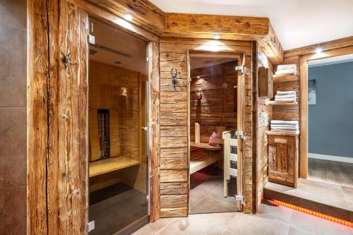 a sauna with wooden walls and a glass door at Gästehaus Tanneck mit Hallenbad in Reit im Winkl