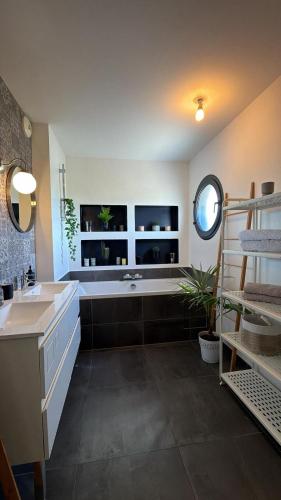 a large bathroom with a tub and a sink at Villa Troyes piscine chauffée sans vis à vis et jacuzzi massant in Saint-André-les-Vergers