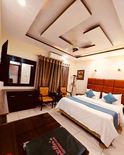 a hotel room with a bed and a table and chairs at Stillers Residency in Rahimyar Khan