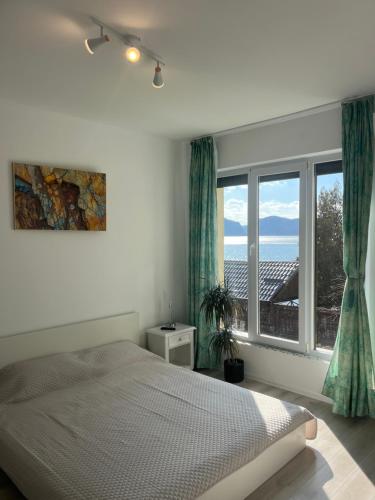 a bedroom with a bed and a large window at Riviera 990 Chalet in (( Ogradena Nouă ))