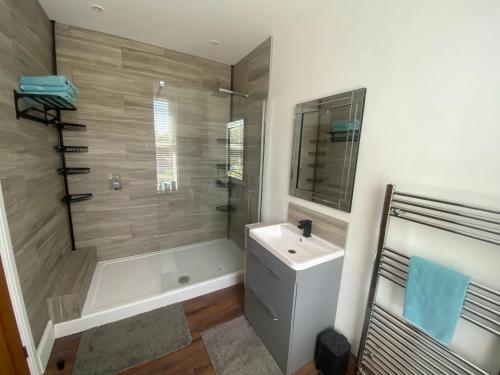 a bathroom with a tub and a sink and a shower at The Dales in Marshside