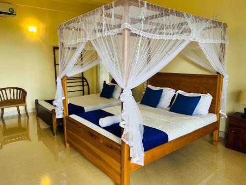 a bedroom with two bunk beds with blue pillows at Nature's Crest Resort in Urulewatta