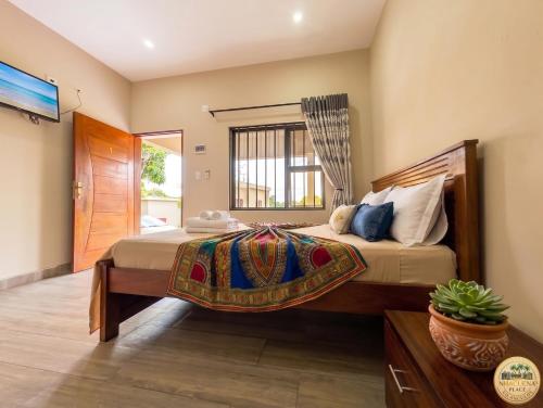 a bedroom with a large bed and a window at Nhacuene's place in Vilanculos
