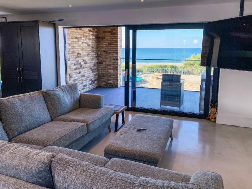 a living room with a couch and a view of the ocean at Glenvar in Falmer