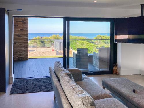 a living room with a couch and a view of the ocean at Glenvar in Falmer