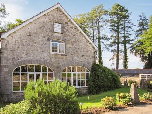 a stone house with large windows at Bailiffs House - Uk48744 in Llandybie