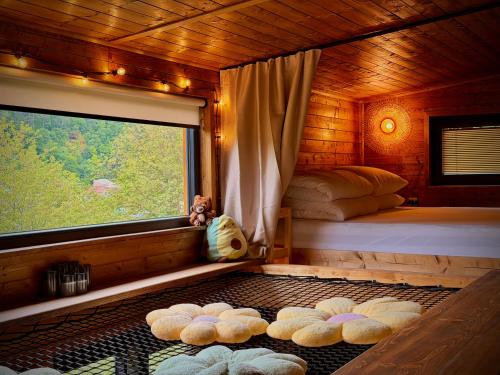 a bedroom with a bed and a window with stuffed animals at Sunny Garden House in Martinske Hole