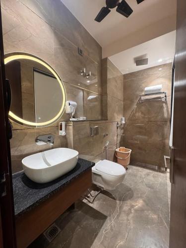 a bathroom with a sink and a toilet and a mirror at Hotel M Stayz Sirsa in Sirsa
