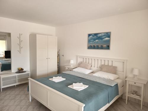 a bedroom with a large bed with two towels on it at Apartments 3 Palms in Crikvenica