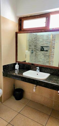 a bathroom with a sink and a mirror at Diani White Sands in Diani Beach