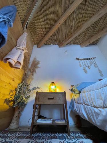 a bedroom with a bed and a table with a night stand at Taida Chalet - Glamping in Villa de Leyva