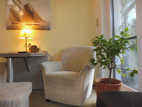 a living room with a chair and a table and a plant at Ferienwohnung Graf Strandgut in Karlshagen
