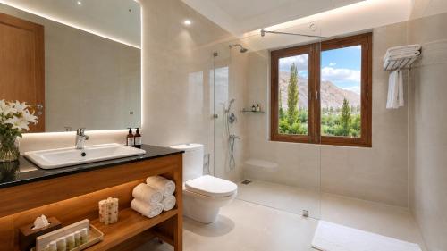 a bathroom with a toilet and a sink and a shower at The Apricot Tree Hotel in Nūrla