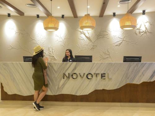 two women standing at a novoited counter in a lobby at Novotel Cairo El Borg in Cairo