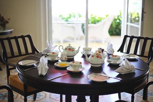 a table with cups and saucers on it at Rumah Luwih Bali in Keramas
